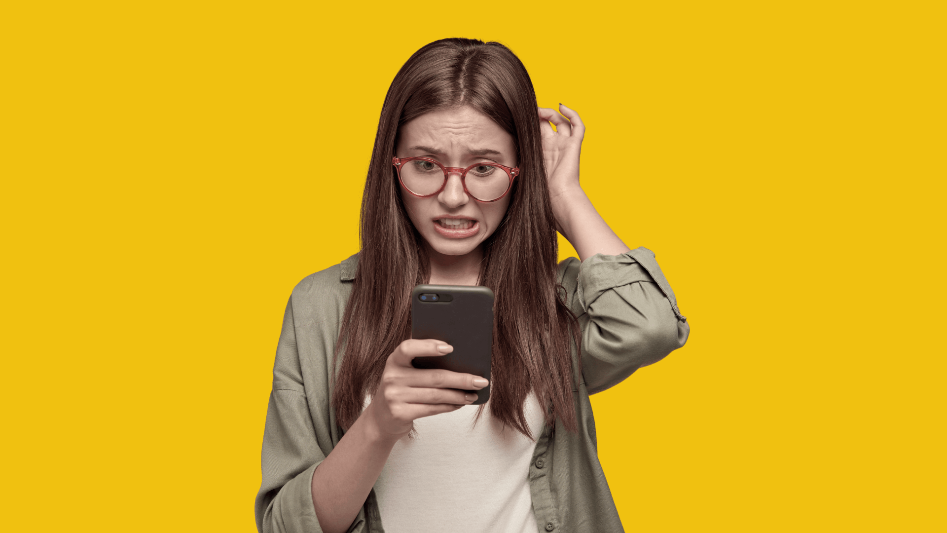 Mujer joven con expresión de confusión y ansiedad mientras observa su teléfono, sobre fondo amarillo. La imagen ilustra el estrés que puede provocar el exceso de opciones tecnológicas, tema central del artículo sobre inteligencia artificial y estrategia personal de Gabriel Patrizzi