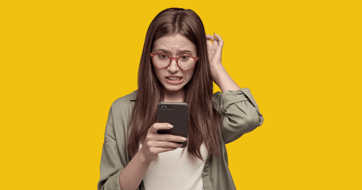 Mujer joven con expresión de confusión y ansiedad mientras observa su teléfono, sobre fondo amarillo. La imagen ilustra el estrés que puede provocar el exceso de opciones tecnológicas, tema central del artículo sobre inteligencia artificial y estrategia personal de Gabriel Patrizzi